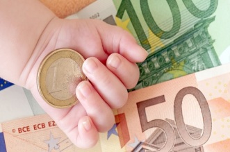 Hand von einem Baby mit Geld