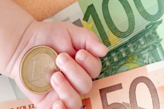 Hand von einem Baby mit Geld